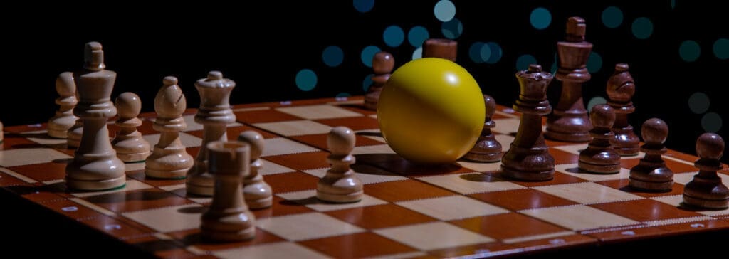 Schaakbord met gele bal als metafoor voor bestuurlijk leiderschap onder druk