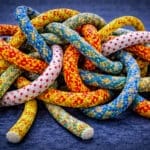 Verstrengelde kleurrijke touwen als metafoor voor een vastgelopen fusie of complexe samenwerking