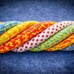 Meerdere kleurrijke touwen in één stevige streng als metafoor voor sterke samenwerking