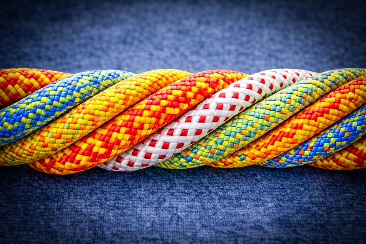 Meerdere kleurrijke touwen in één stevige streng als metafoor voor sterke samenwerking
