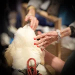 Handen van ouderen raken Roos aan tijdens een warm moment van contact en aandacht