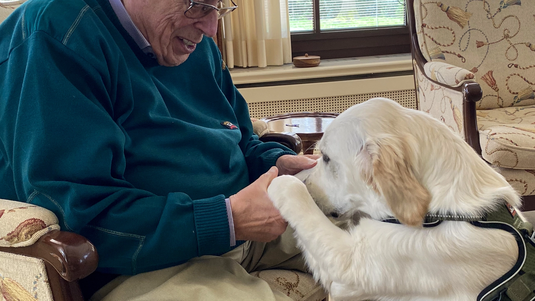Oudere man maakt warm contact met Roos tijdens Vachtkracht-vrijdag in een huiselijke setting